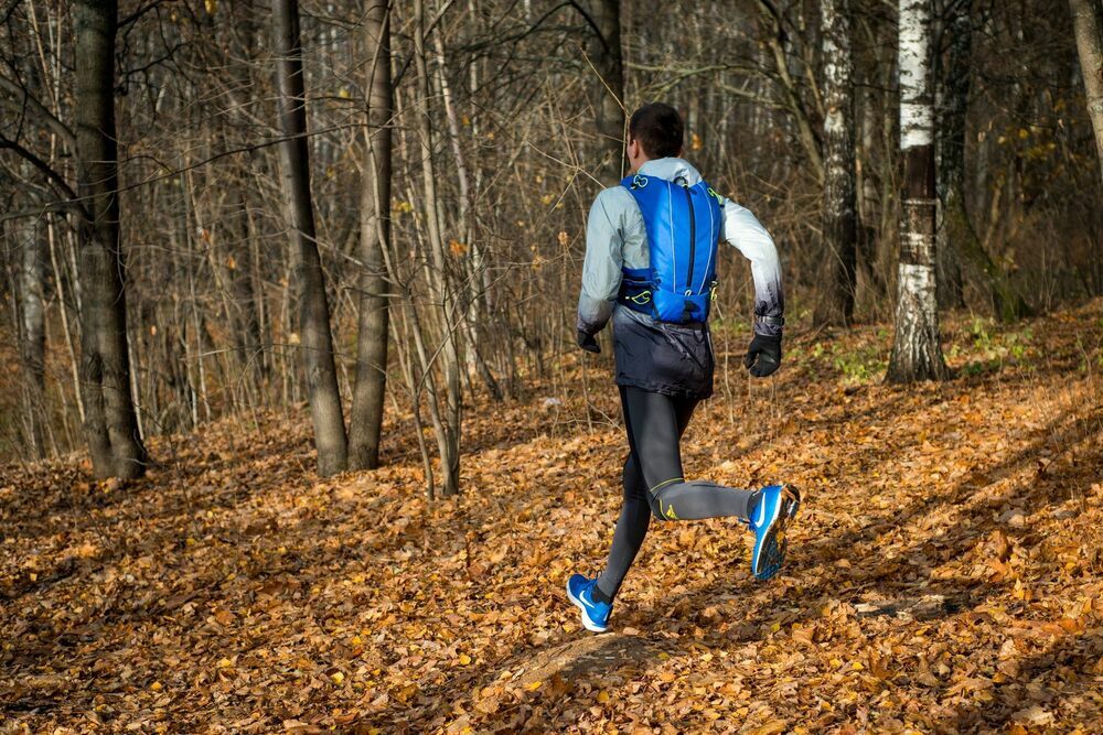 На фотографии студент бежит по осеннему десу